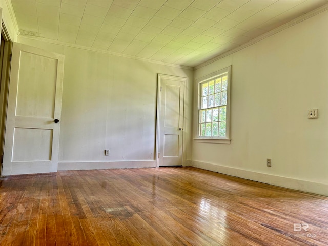 spare room with crown molding and light hardwood / wood-style floors