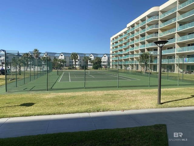 view of tennis court featuring a yard