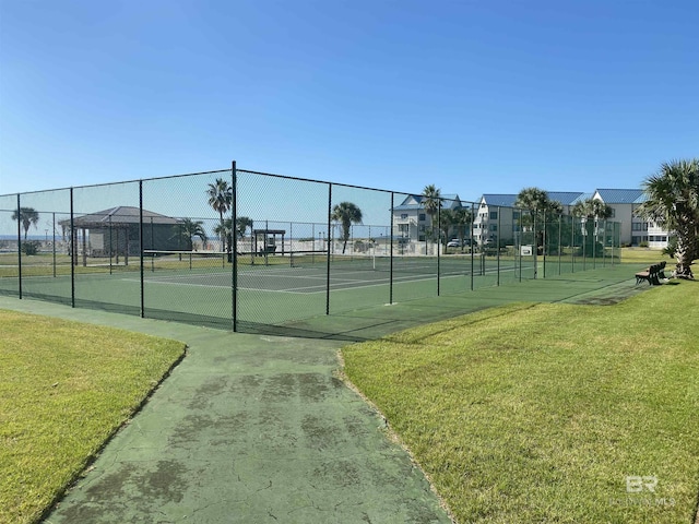 view of tennis court featuring a lawn