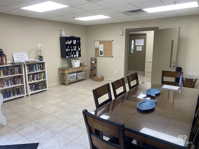 tiled dining area featuring a paneled ceiling