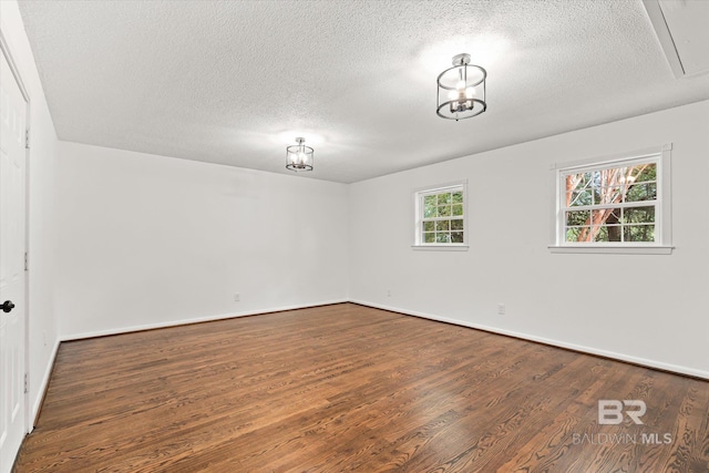 empty room with hardwood / wood-style flooring and a textured ceiling