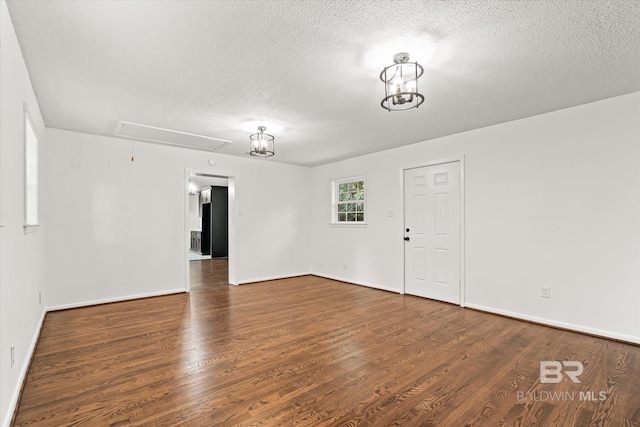 spare room with dark hardwood / wood-style flooring and a textured ceiling