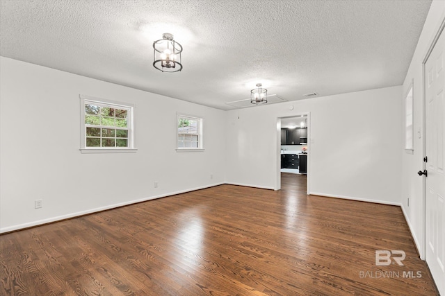 unfurnished room featuring dark hardwood / wood-style flooring and a textured ceiling