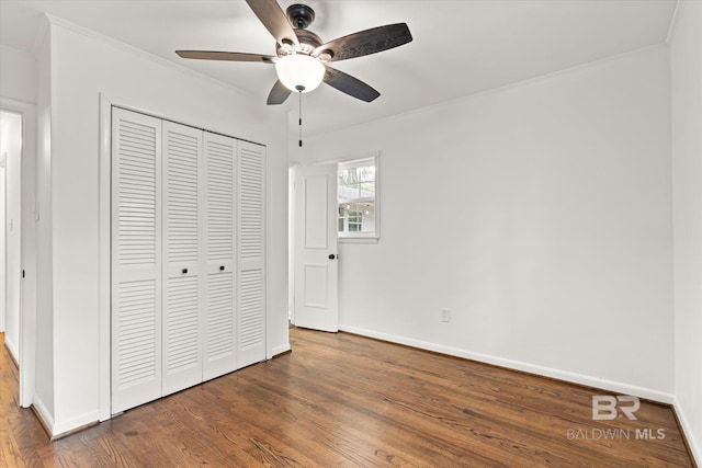 unfurnished bedroom with dark hardwood / wood-style flooring, a closet, ceiling fan, and ornamental molding