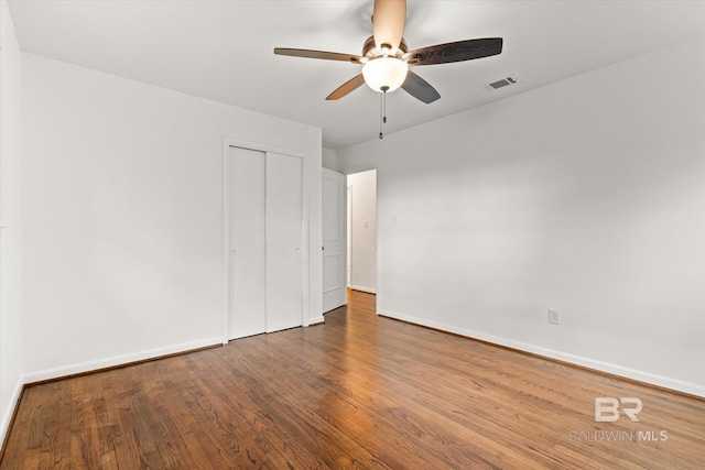 unfurnished bedroom with a closet, hardwood / wood-style flooring, and ceiling fan