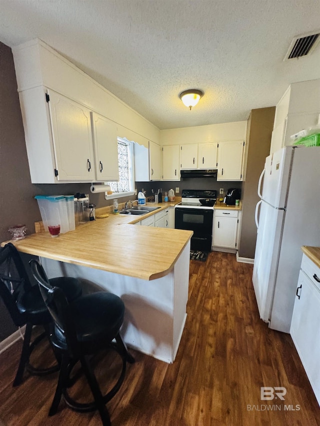 kitchen with dark wood-type flooring, sink, range with electric stovetop, white refrigerator, and kitchen peninsula