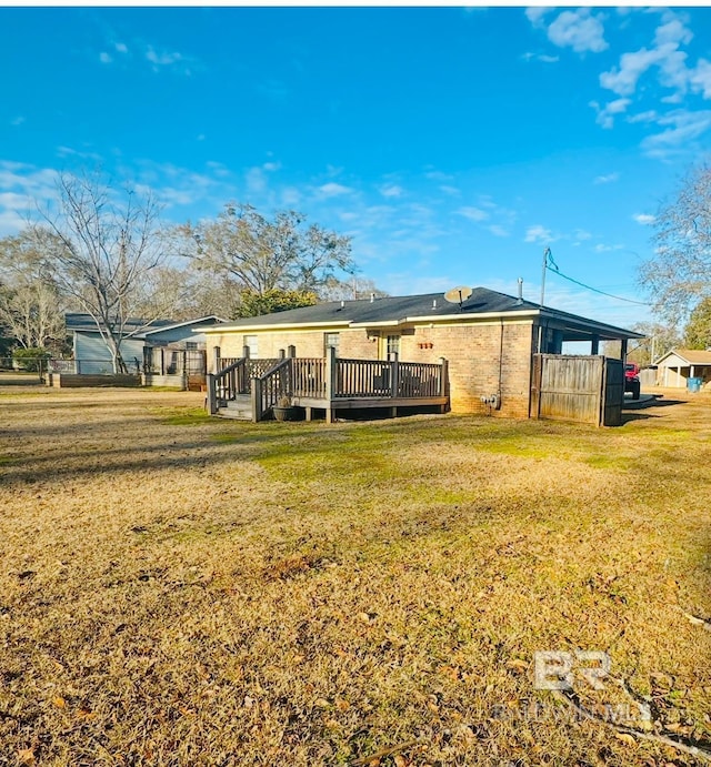 rear view of house featuring a deck and a lawn