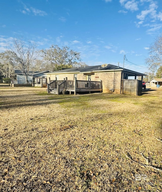 back of house featuring a wooden deck and a lawn