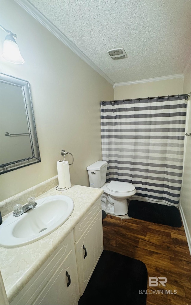 bathroom with crown molding, vanity, hardwood / wood-style floors, and a textured ceiling