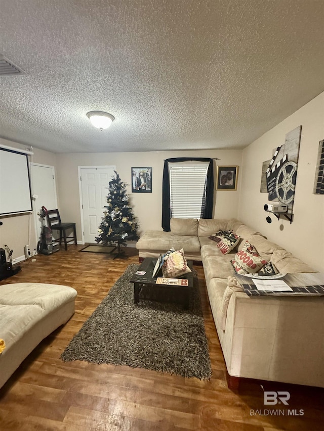 living room featuring dark wood-type flooring and a textured ceiling