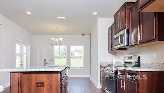 kitchen with sink, stainless steel appliances, light stone counters, dark hardwood / wood-style flooring, and a chandelier