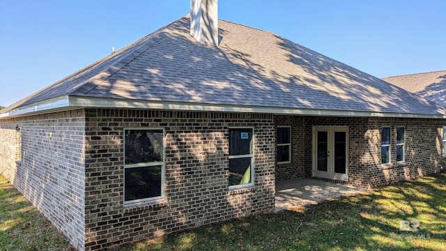 rear view of property with a lawn and a patio