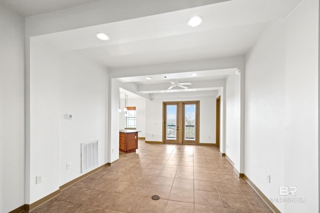 tiled empty room with beamed ceiling and ceiling fan