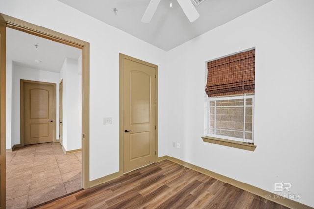 tiled empty room with ceiling fan