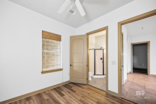 unfurnished bedroom featuring connected bathroom, ceiling fan, and hardwood / wood-style floors