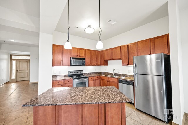 kitchen with stainless steel appliances, decorative light fixtures, sink, and light tile floors