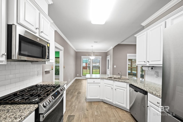 kitchen featuring stainless steel appliances, white cabinetry, light hardwood / wood-style floors, and sink