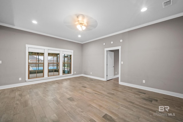 spare room featuring hardwood / wood-style floors, ceiling fan, and crown molding