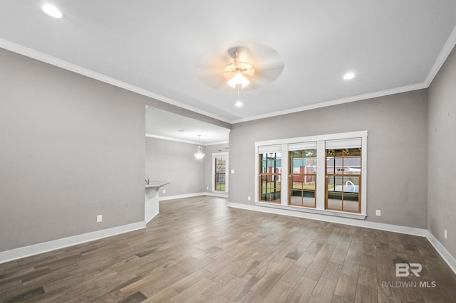 unfurnished living room featuring hardwood / wood-style floors, ceiling fan, and crown molding