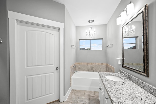 bathroom with a bathtub, vanity, and an inviting chandelier