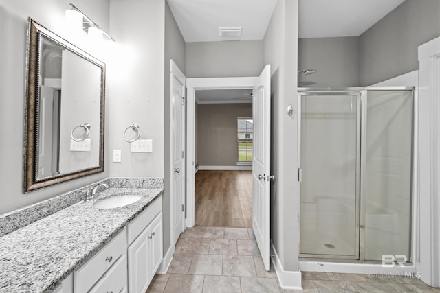 bathroom with hardwood / wood-style floors, vanity, and walk in shower