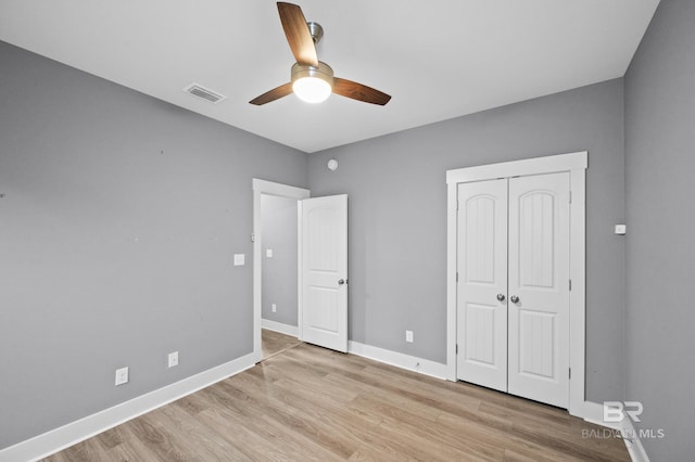 unfurnished bedroom with ceiling fan, a closet, and light wood-type flooring