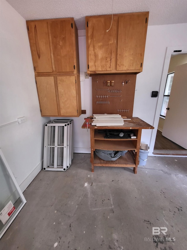 dining room featuring a workshop area, unfinished concrete floors, and baseboards