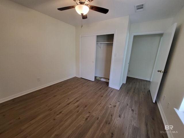 unfurnished bedroom featuring dark wood-style flooring, a closet, baseboards, and a ceiling fan