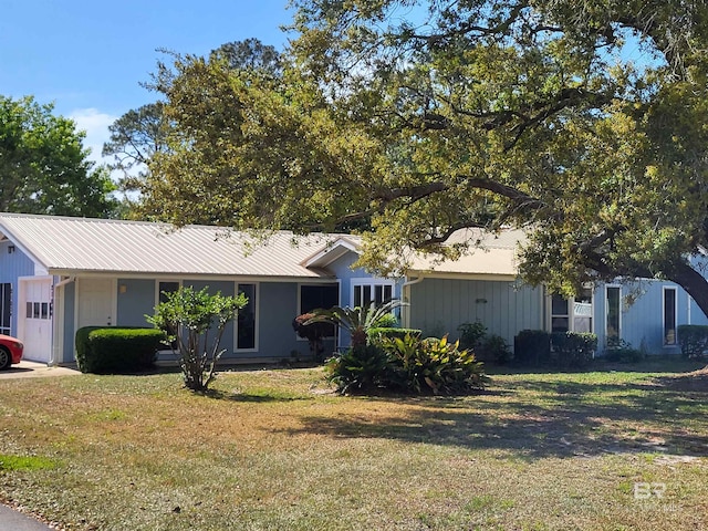 view of front facade with a front yard and metal roof