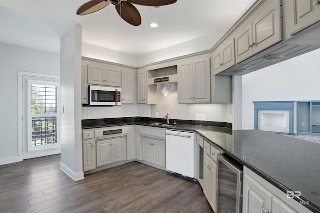 kitchen featuring dark hardwood / wood-style flooring, white appliances, ceiling fan, sink, and wine cooler