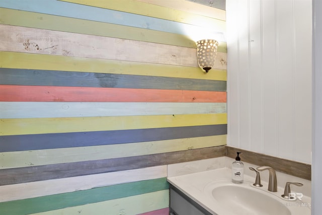 bathroom featuring wood walls and vanity