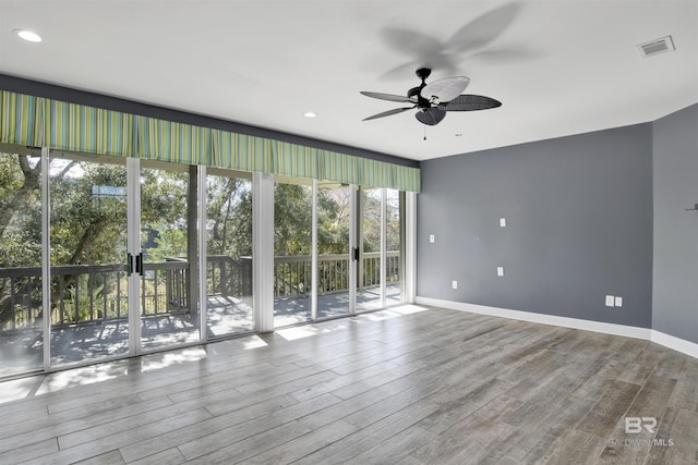 unfurnished room with hardwood / wood-style flooring and ceiling fan