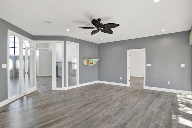 empty room featuring ceiling fan, french doors, and wood-type flooring