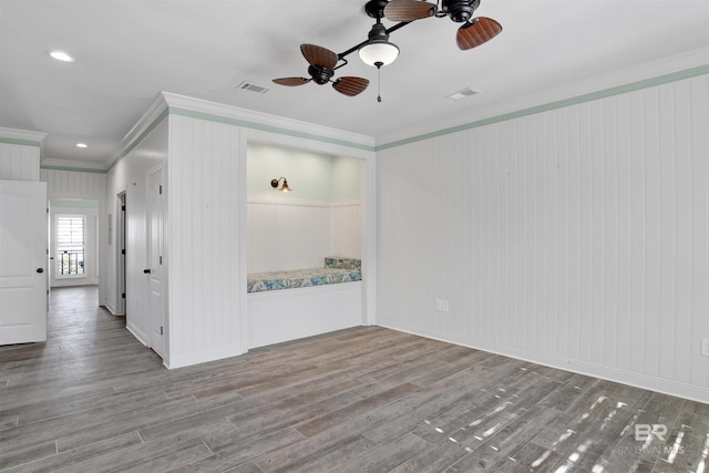 empty room with ceiling fan, light wood-type flooring, and ornamental molding