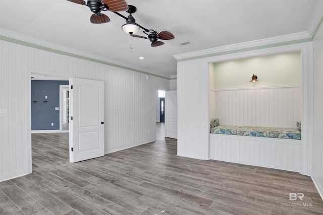 unfurnished living room featuring ceiling fan, light wood-type flooring, and ornamental molding