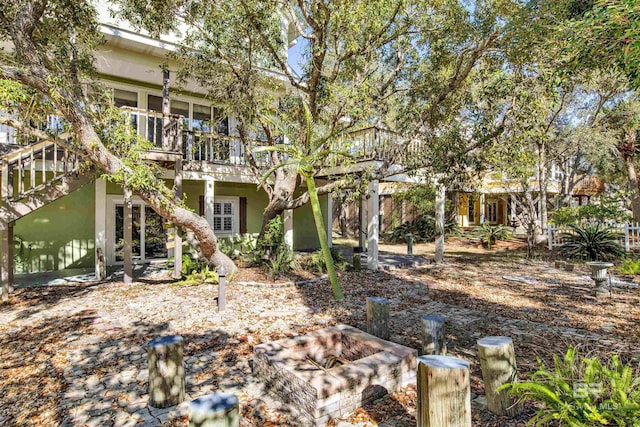 rear view of property featuring a fire pit