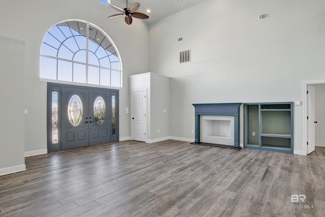 entryway with ceiling fan, a high ceiling, and hardwood / wood-style flooring