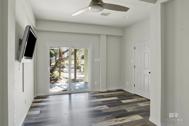 foyer entrance with ceiling fan and dark wood-type flooring