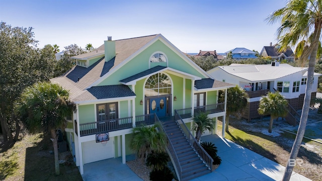 view of front of house featuring french doors, a garage, and a porch