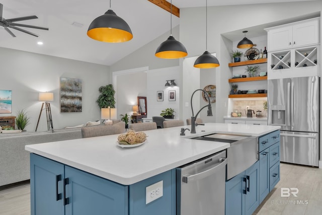 kitchen featuring open shelves, appliances with stainless steel finishes, blue cabinetry, a ceiling fan, and open floor plan
