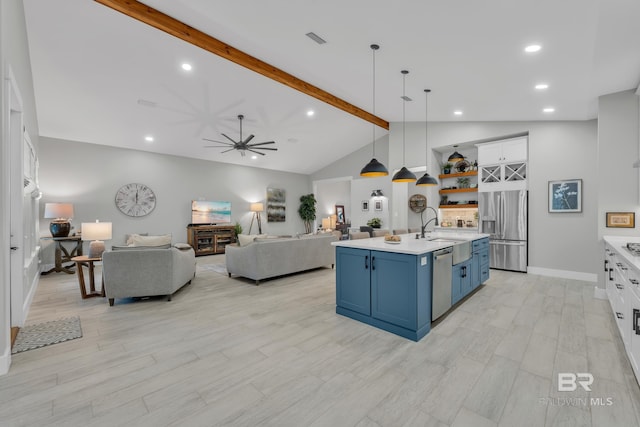 kitchen with blue cabinets, beamed ceiling, appliances with stainless steel finishes, and light countertops