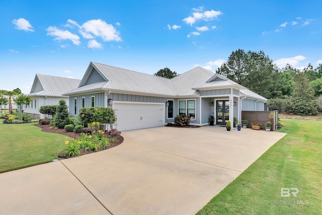 view of front of home with an attached garage, a front lawn, board and batten siding, concrete driveway, and french doors
