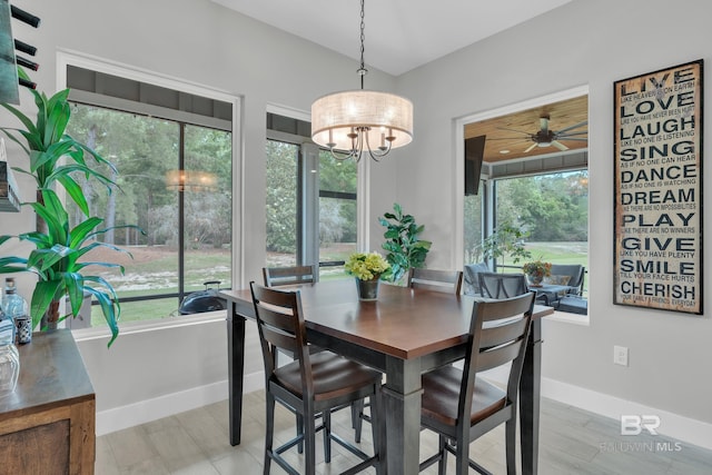 dining space with baseboards, ceiling fan with notable chandelier, and a wealth of natural light
