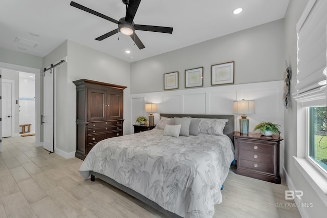 bedroom with recessed lighting, a barn door, and ceiling fan