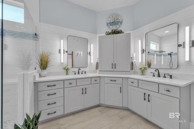 bathroom featuring double vanity, a sink, and a tile shower