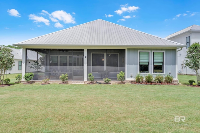view of front facade with board and batten siding, a sunroom, metal roof, and a front yard