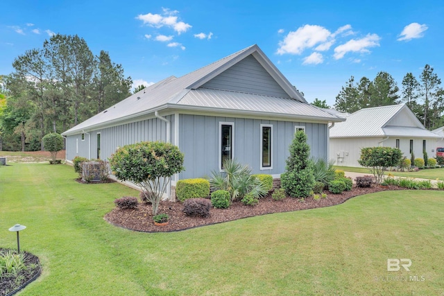 view of side of home featuring a yard, board and batten siding, and metal roof
