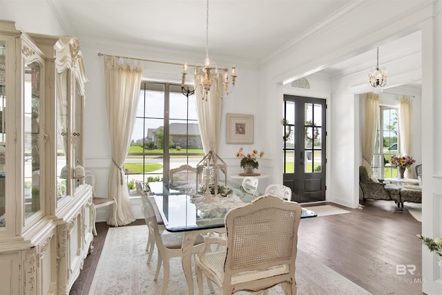 dining area with crown molding, wood finished floors, and a chandelier
