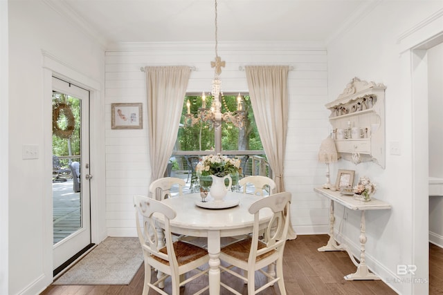 dining room with crown molding, baseboards, and wood finished floors