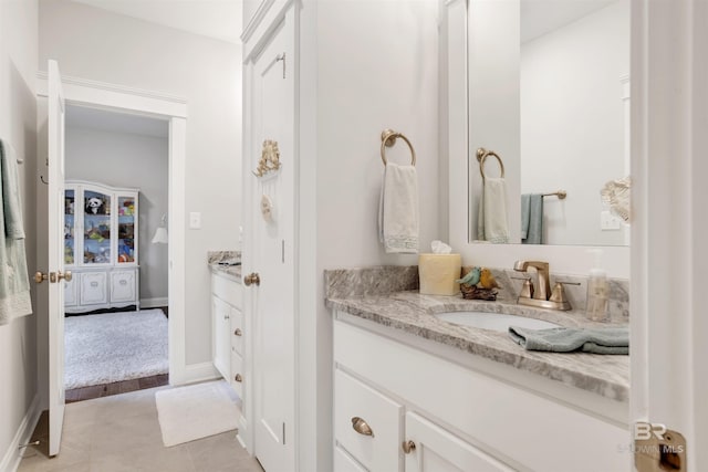 bathroom featuring baseboards, tile patterned flooring, and vanity